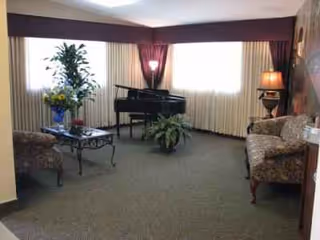 Cozy interior living room with piano, plants, and comfortable seating.