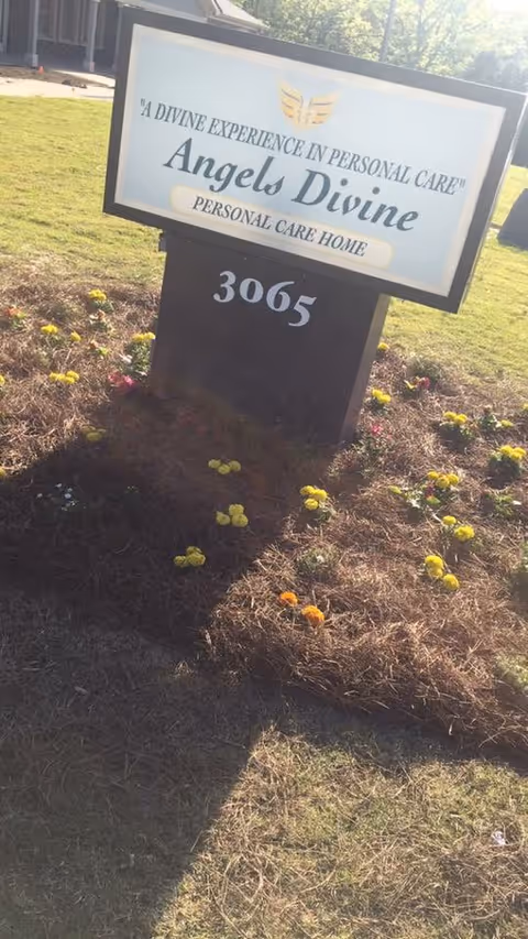 A front lawn sign reading "Angels Divine Personal Care Home" with the number 3065 surrounded by mulch and small flowers.