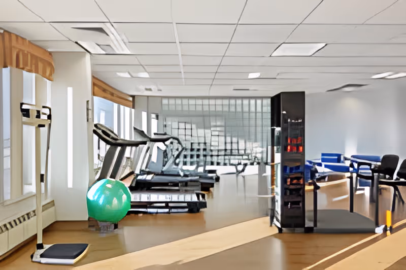 Interior fitness room with treadmills, an exercise ball, a scale and a seating area.