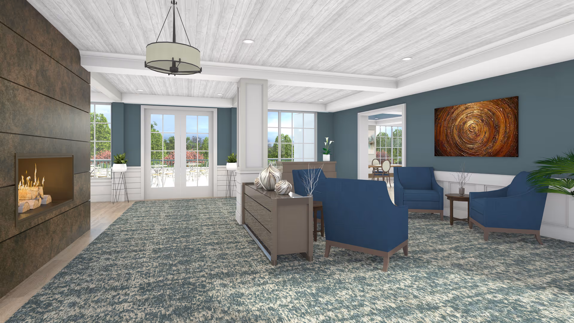 A spacious living room area with blue armchairs arranged around a small wooden table. The room features a modern fireplace on the left wall, large windows and glass doors letting in natural light, and a decorative abstract painting on the right wall. The ceiling has white wooden beams and a hanging light fixture, and the floor is covered with a patterned blue and gray carpet.