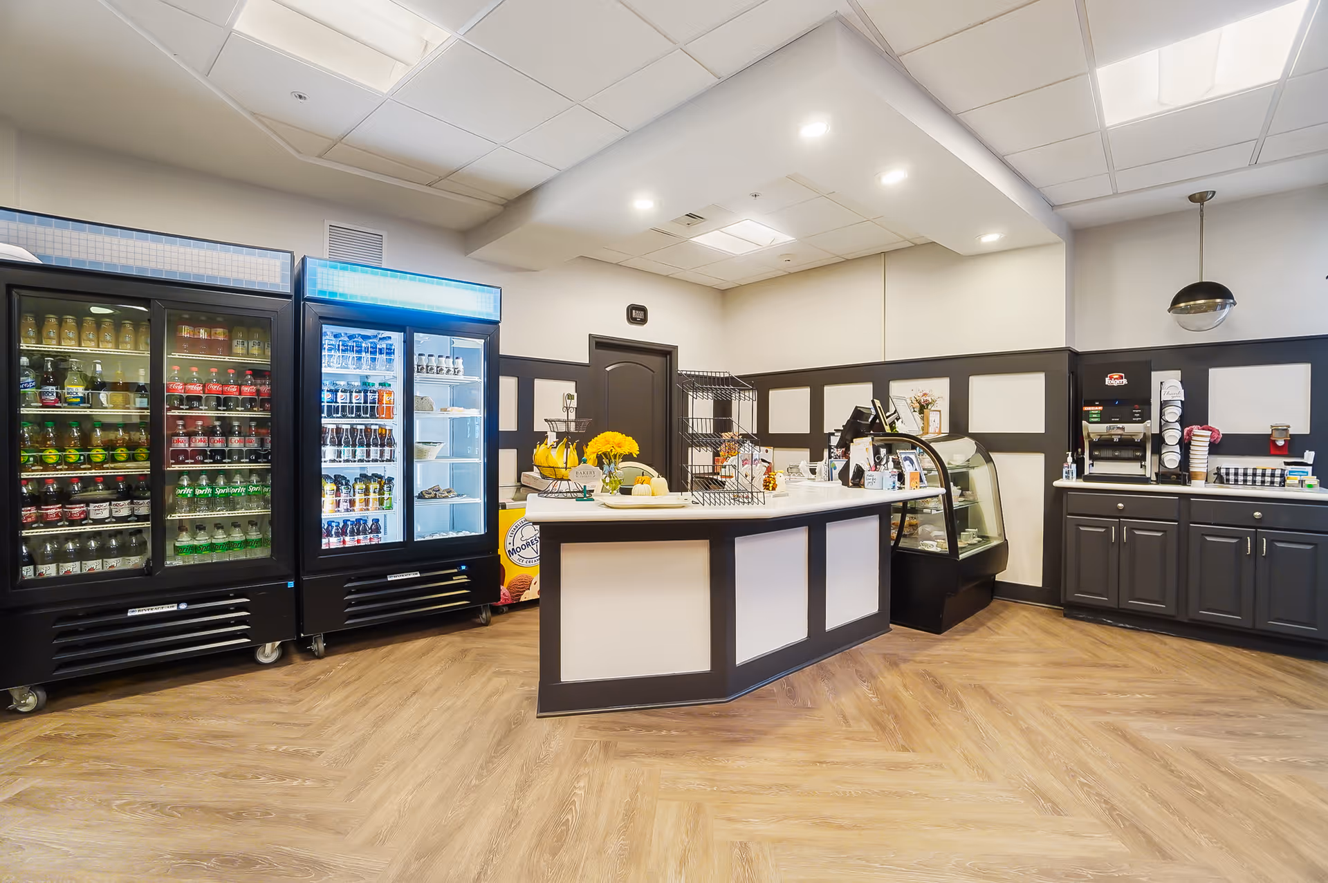 Interior snack bar area with refrigerated display cases, a central service counter, and a coffee station.