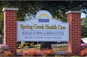 Sign with brick pillars reading Spring Creek Health Care, Skilled Nursing & Rehab Center, with landscaping.