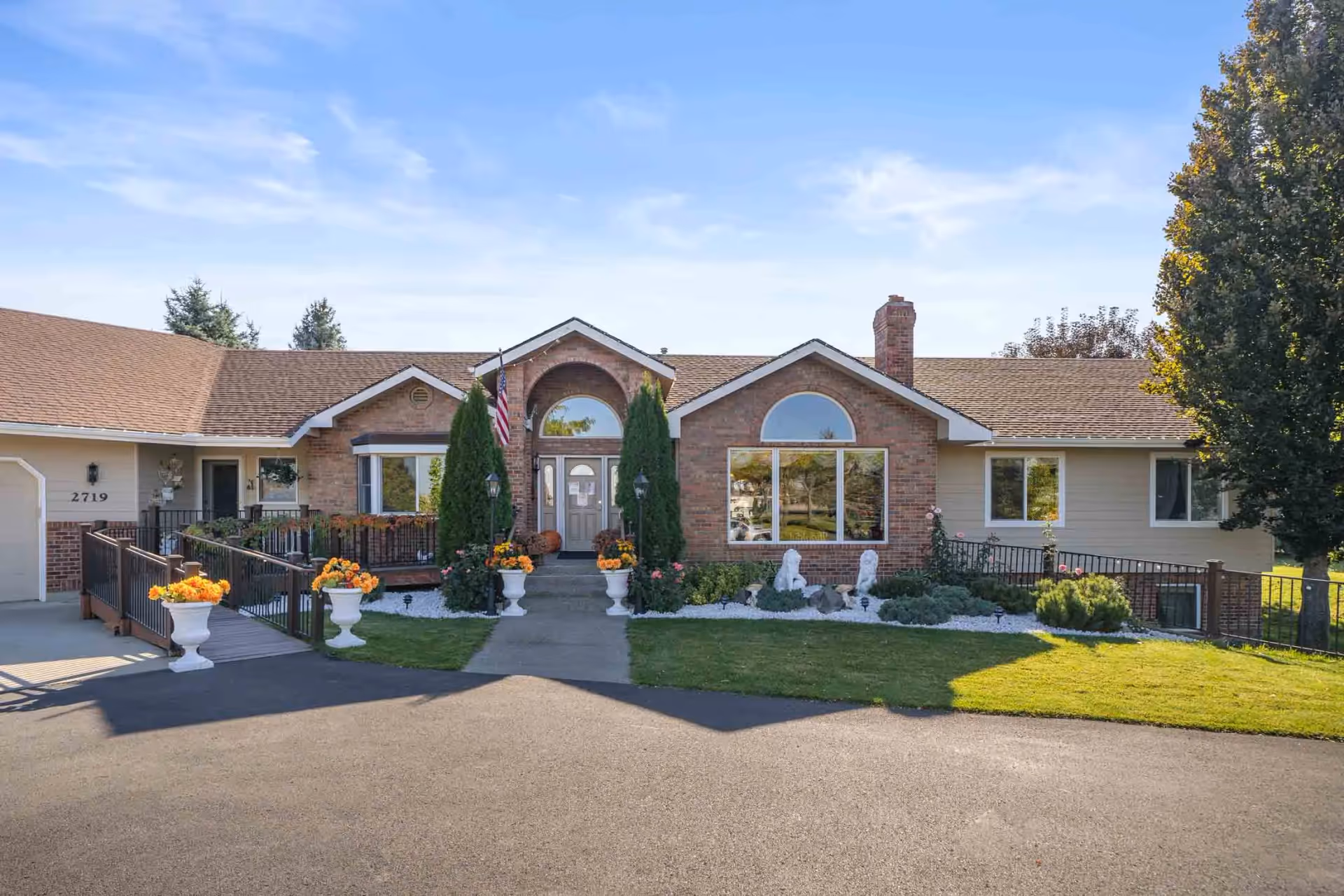 Front exterior view of Providence Adult Family Home with brick facade, arched entry, and landscaped walkway.