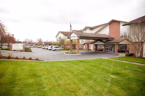 Exterior view of Rosewood Park senior living facility with entrance and parking.