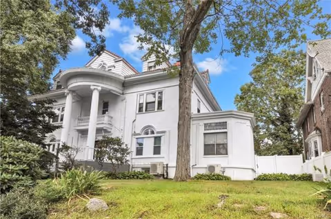 Chester Hill Adult Home exterior: white, multi-story building with columns, trees, and lawn.
