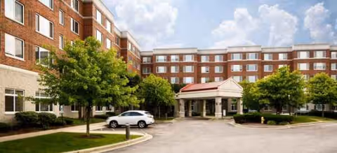 Brookdale Northbrook exterior: brick senior living building with covered entrance and trees.