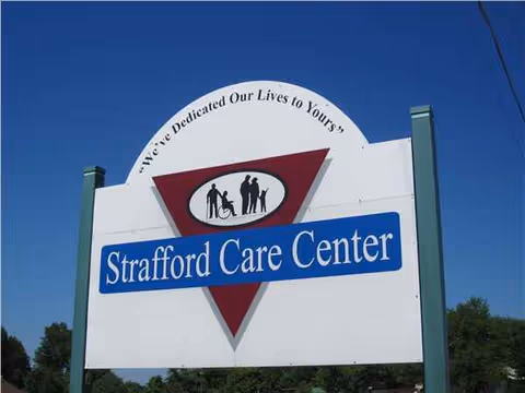 Sign for Strafford Care Center on green posts against a blue sky.