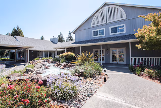 Exterior view of Cogir of Rohnert Park with landscaped pathway and water feature.