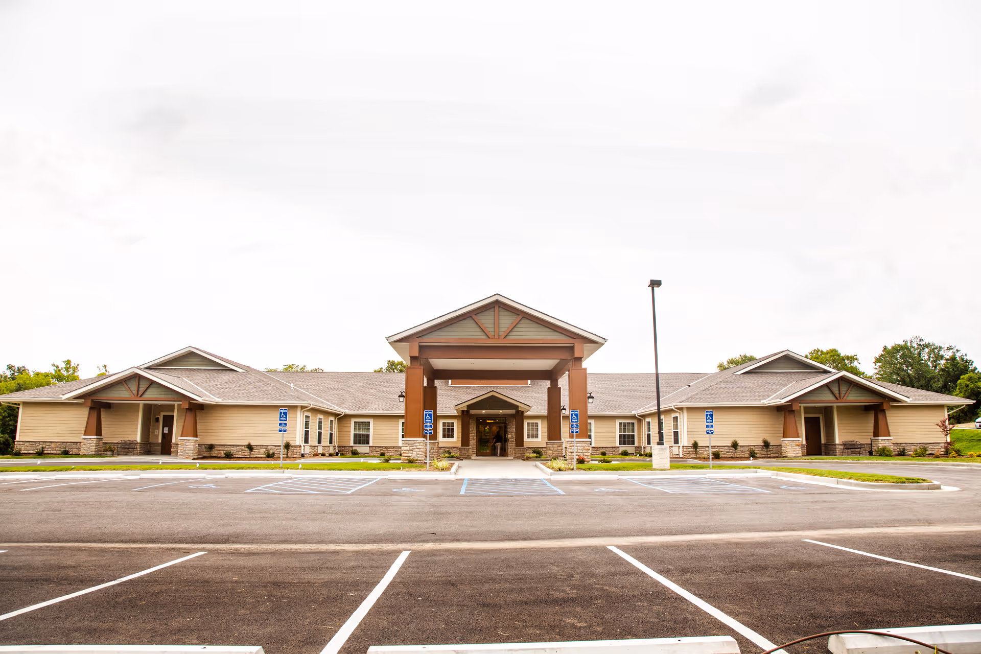 Front view of the Oak Pointe of Rolla senior living building with a covered entrance and empty parking lot.