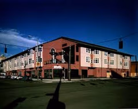 Exterior view of Nikkei Manor, a brick senior living facility on a street corner.