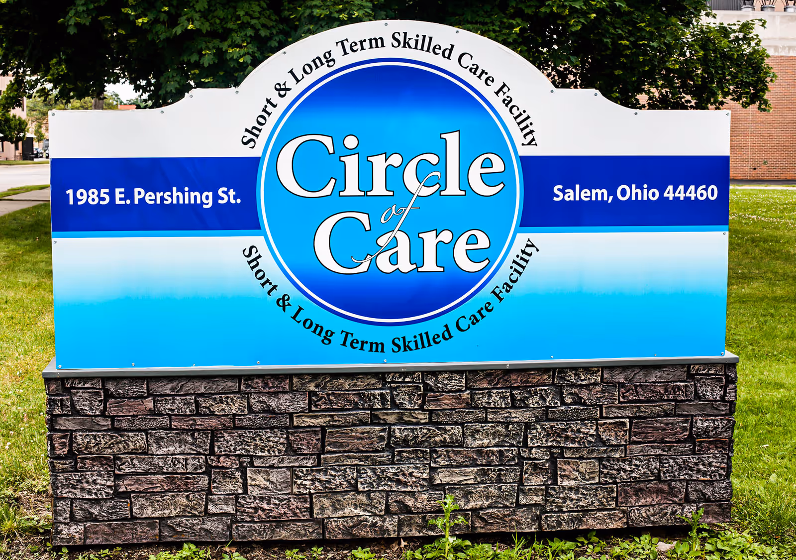 Outdoor sign for Circle of Care, a short and long term skilled care facility located at 1985 E. Pershing St., Salem, Ohio 44460, with a blue and white design mounted on a stone base.