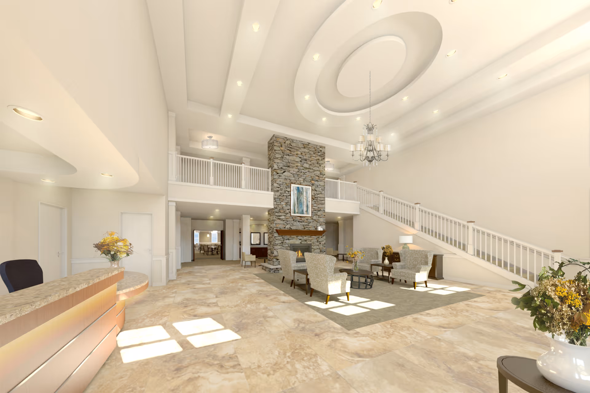 A spacious and bright senior living facility lobby with a high ceiling featuring recessed lighting and a chandelier. The room includes a stone fireplace with a painting above it, several upholstered chairs arranged around a coffee table on a rug, a reception desk with a chair, and a staircase with white railings leading to an upper level. There are flower arrangements on tables and natural light coming through windows.