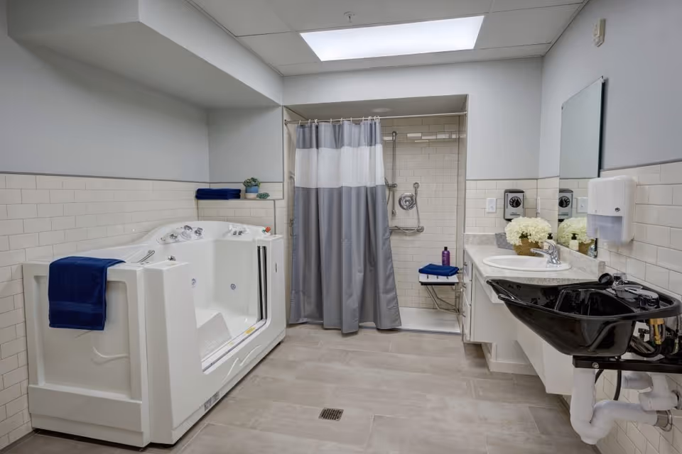 Accessible bathroom with a walk-in tub, roll-in shower with grab bars, dual sinks and a black salon-style basin.