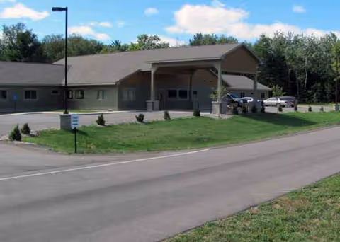 Culver Meadows Senior Living exterior with covered entry and parked cars.