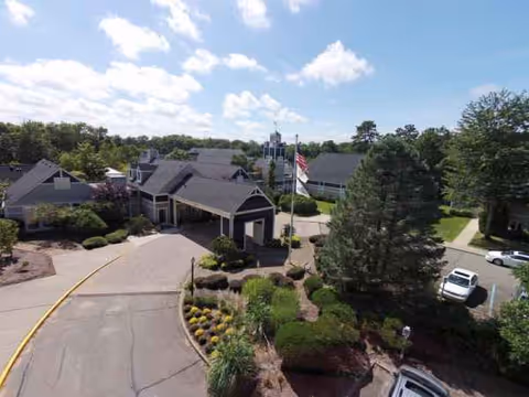 Aerial view of Harrogate Retirement Community front with drive, flag, and landscaping.