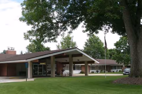Exterior view of Rotary Senior Living with a covered entrance and green lawn.