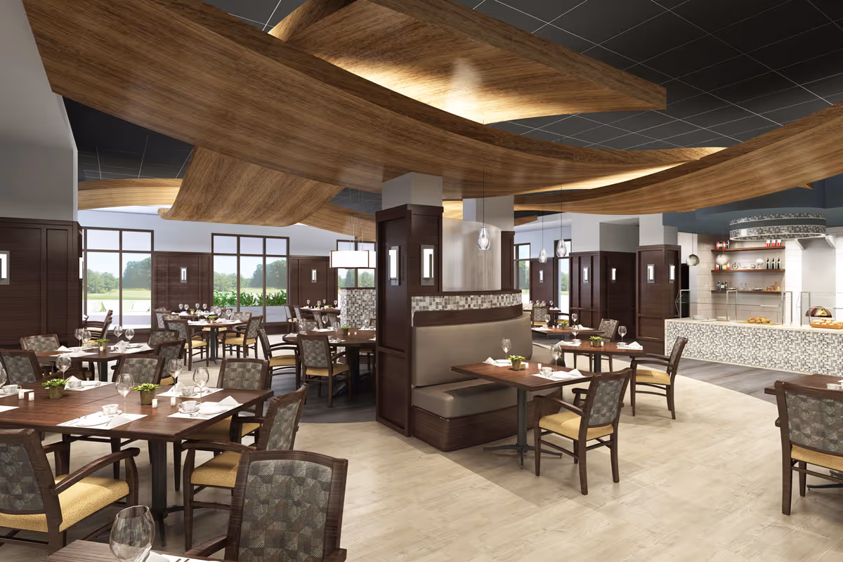 A spacious and modern dining room with multiple wooden tables and cushioned chairs arranged neatly. The ceiling features artistic wooden wave-like panels with integrated lighting. Large windows allow natural light to brighten the room, and a serving counter with a mosaic tile front is visible in the background.
