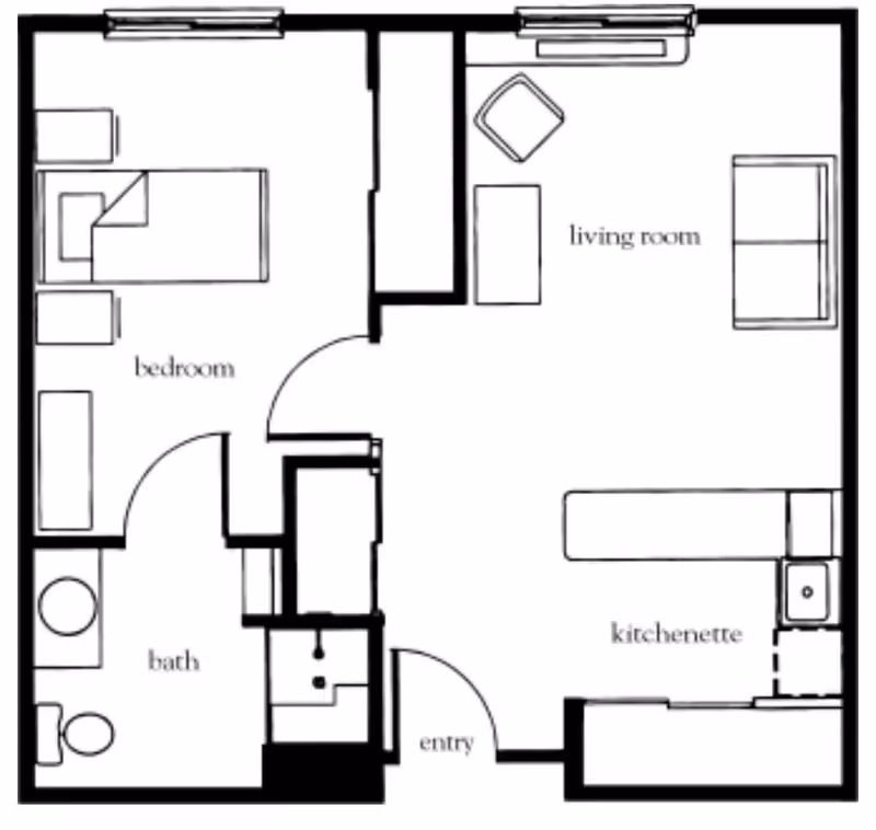 Black and white architectural floor plan of a small apartment unit showing a bedroom with a bed and two nightstands, a bathroom with a toilet and sink, a living room with a sofa, chair, and coffee table, and a kitchenette with a sink and counter space. The entry door is located near the kitchenette.