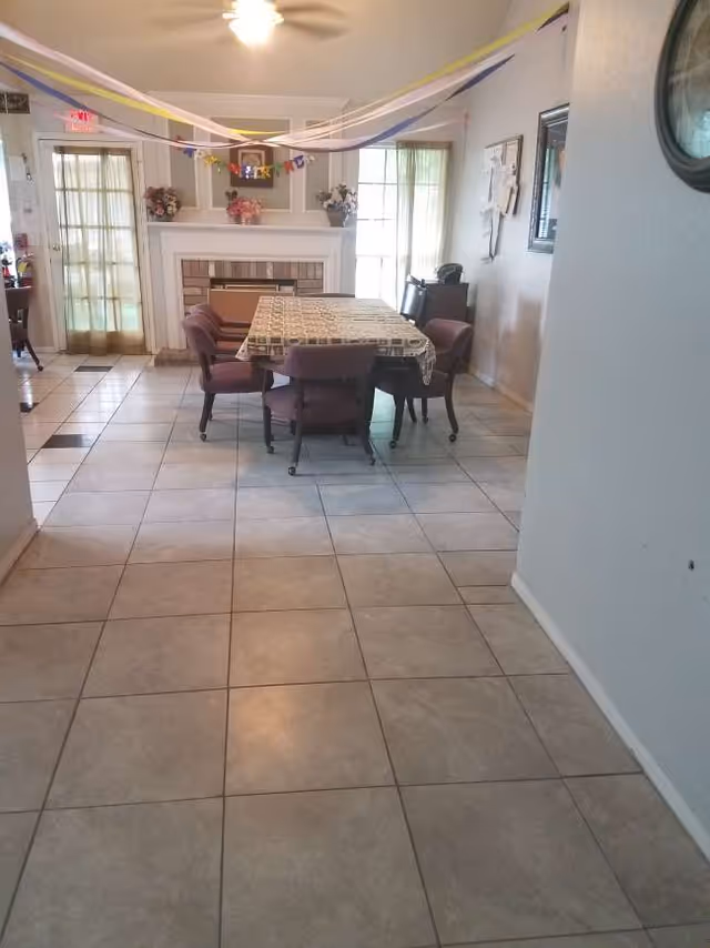 Dining room with a table, six chairs, streamers, and a fireplace.