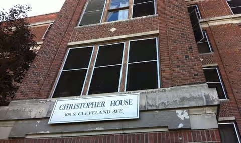Brick building facade with a Christopher House sign above the entrance.