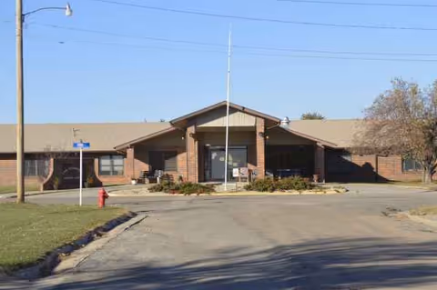 Front exterior of Linn Community Nursing Home showing brick building, driveway, and entrance.