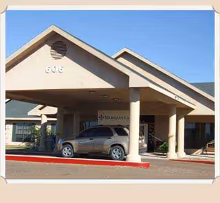 Front entrance of Meridian Care of Hebbronville with porte-cochere and SUV parked.
