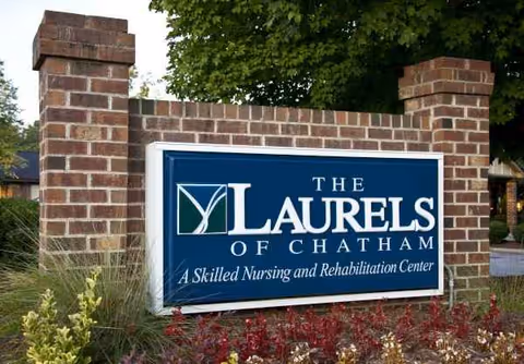 Brick entrance pillars flank a blue sign reading The Laurels of Chatham.