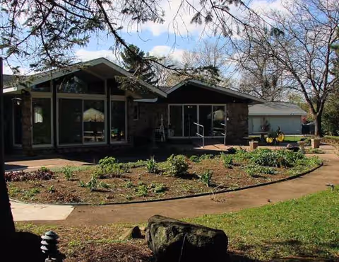 Front view of Willow Haven CBRF with garden beds and walkway outside.