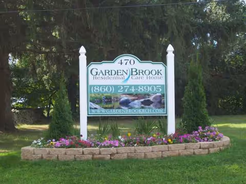 Garden Brook sign at entrance with flower bed and trimmed lawn