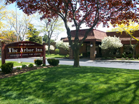 Exterior view of Arbor Inn assisted living facility with sign and manicured lawn