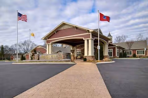 Exterior view of Life Care Center of Hixson with covered entrance and flags.
