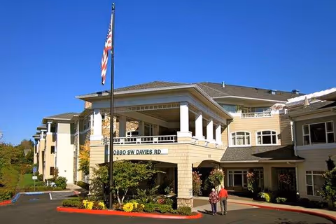 Exterior view of Hearthstone at Murrayhill showing the entrance with flagpole and pedestrians.
