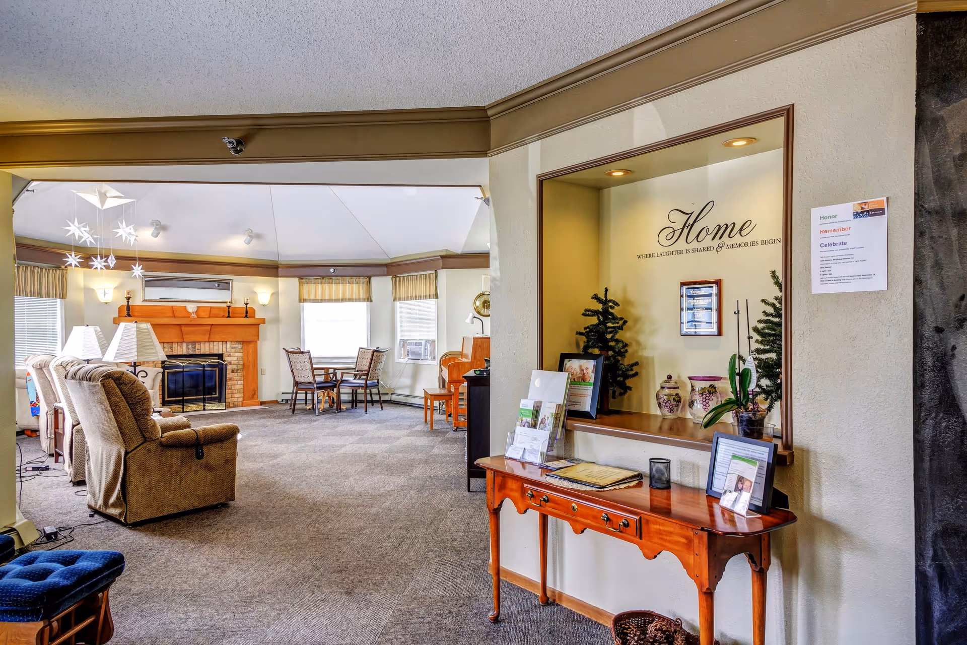 Spacious senior living lounge with couches, a fireplace, and a reception area.