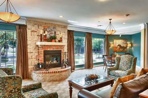 Cozy living room with stone fireplace, large windows, and comfortable seating.