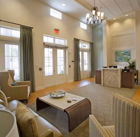 Bright lobby with seating area, reception desk, and double doors at Ortega Gardens