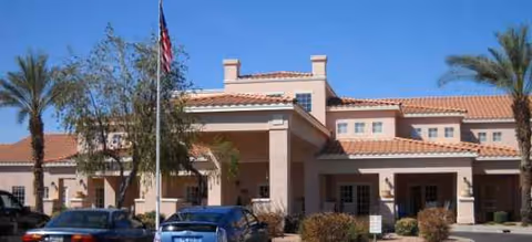 Exterior view of Brookdale Chandler Regional senior living building with palm trees and cars.