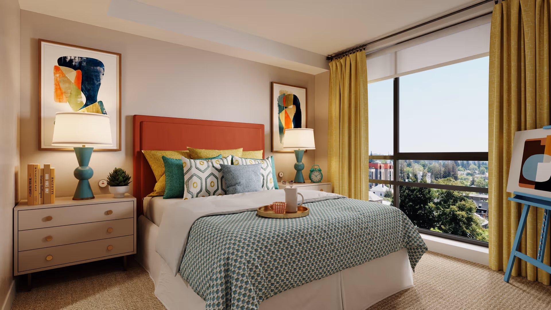 A bright bedroom with a large window showing a scenic view outside. The room features a bed with a red headboard, multiple decorative pillows, and a patterned bedspread. There are two bedside tables, each with a lamp and decorative items. Yellow curtains frame the window, and an easel with abstract art is visible on the right side.