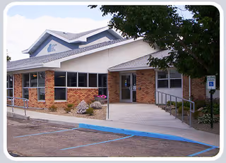 The exterior view of the Napoleon Care Center featuring a brick facade and landscaped entrance.