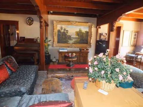 Royal Garden Guest Home lounge with sofas, a coffee table, and a large framed painting.