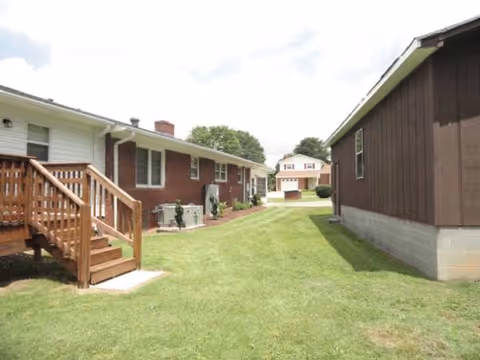 Outdoor view of brick and wood senior living buildings with a central grassy path