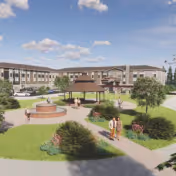 Front exterior of a multi-story senior living building with a landscaped courtyard, gazebo, fountain, and people walking on paved paths.