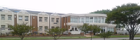 Exterior view of Shepherd's Village at Park Avenue, a multi-wing senior living facility with trees.