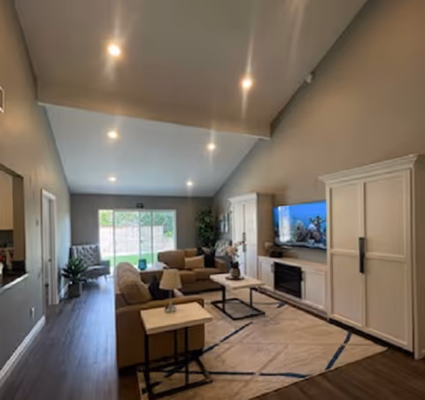 Bright living room with beige sofas, coffee tables, and large windows.