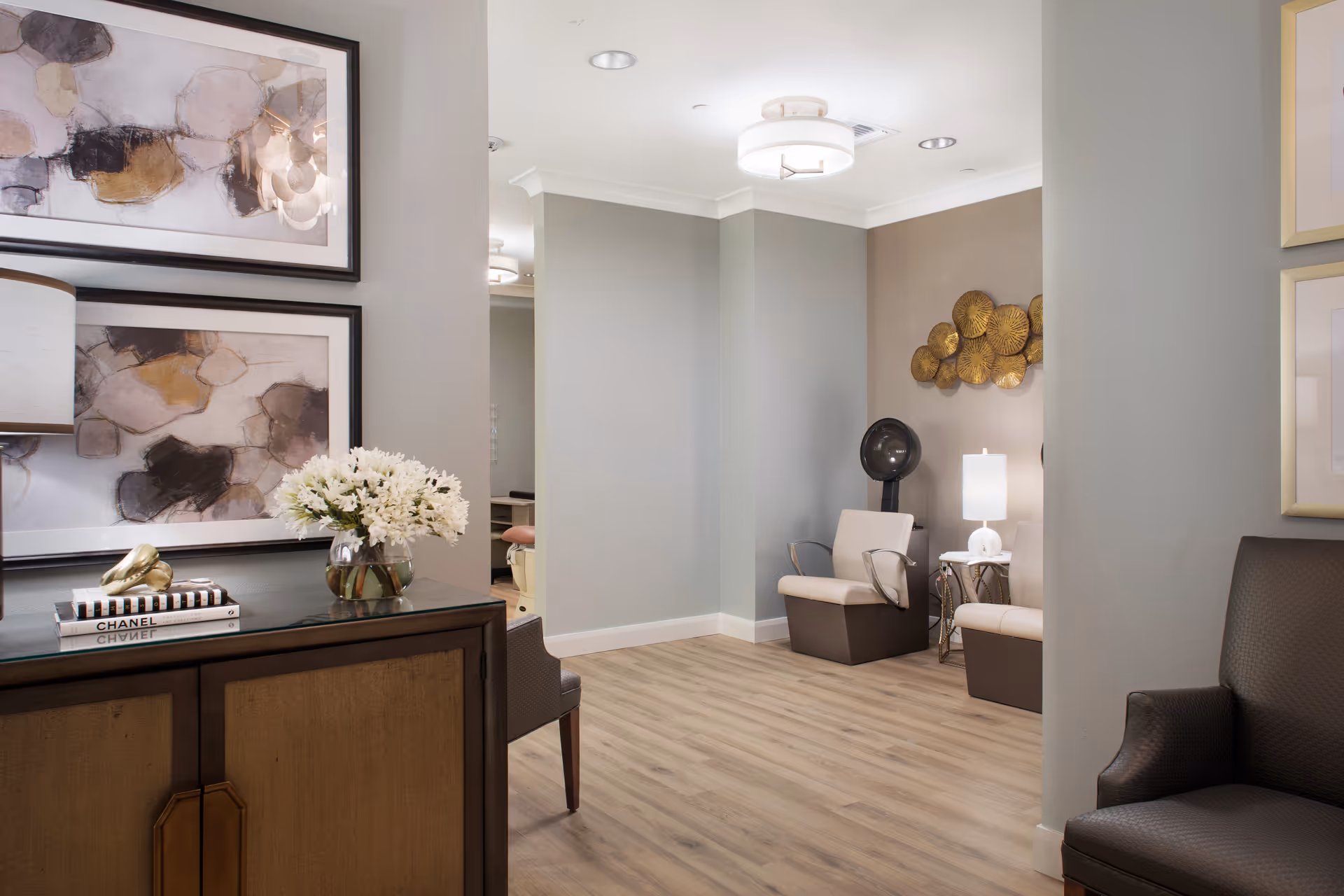 Modern senior living lobby featuring artwork, flowers, a console table, and lounge seating.