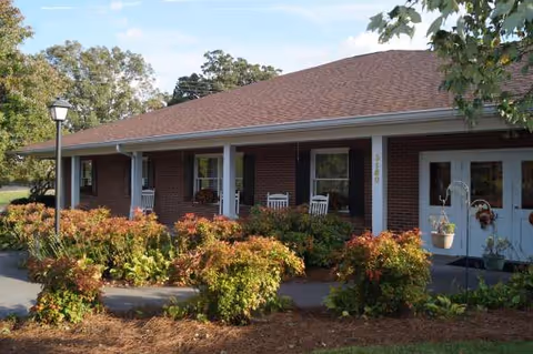 Exterior of Danby House, a single-story brick senior living facility with porch and shrubs.