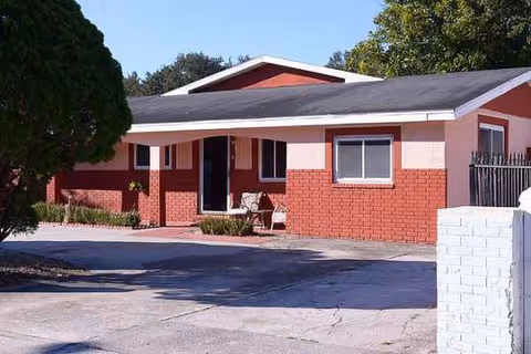 Front of a red brick assisted-living building with driveway.