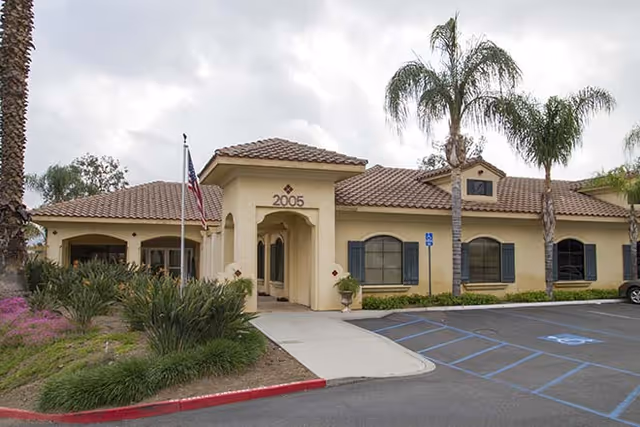 Exterior view of a single-story Brookdale Corona senior living facility with a covered entrance.