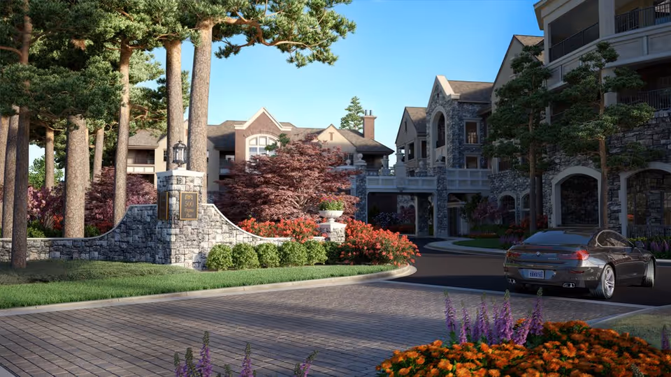 Exterior view of The Terraces at Peachtree Hills Place with landscaped entrance and parked car.