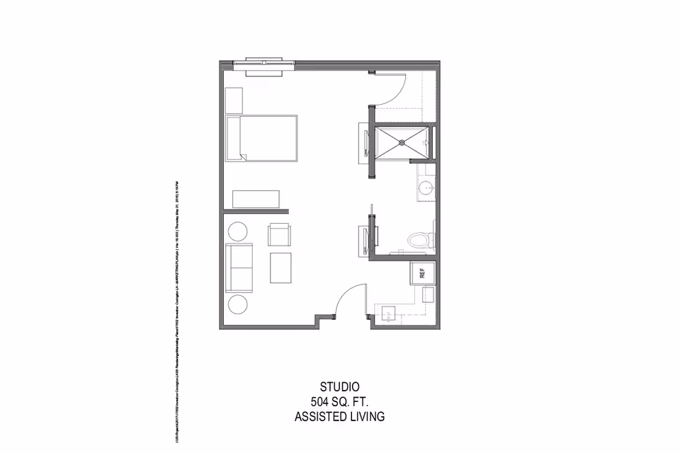 Floor plan of a 504 square foot assisted living studio apartment at Sage Lake, showing a combined living and sleeping area with a bed, sofa, chairs, and tables, a kitchenette with a refrigerator, and a bathroom with a shower, toilet, and sink.