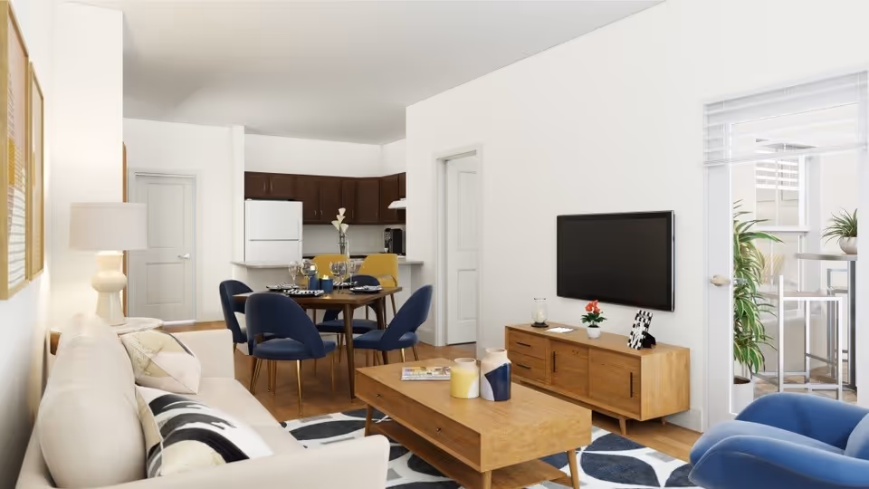 Bright, modern open-concept living room with a beige sofa, wooden coffee table, wall-mounted TV, and a dining area leading to a kitchen.
